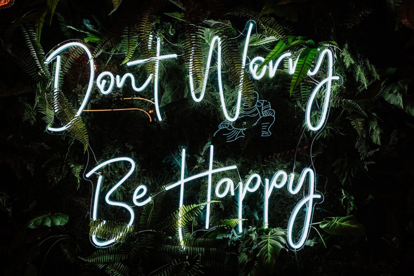 a neon sign that says don't worry be happy